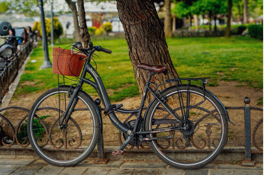 Колело с пластмасова кошница, паркирано в зелено пространство