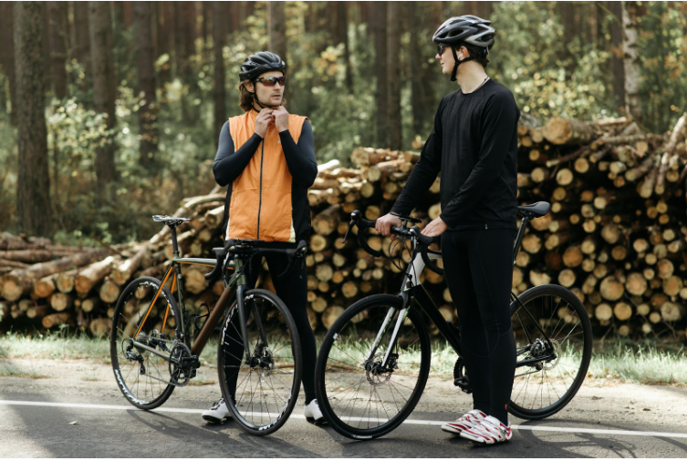 двама планински колоездачи си говорят, докато си слагат каските