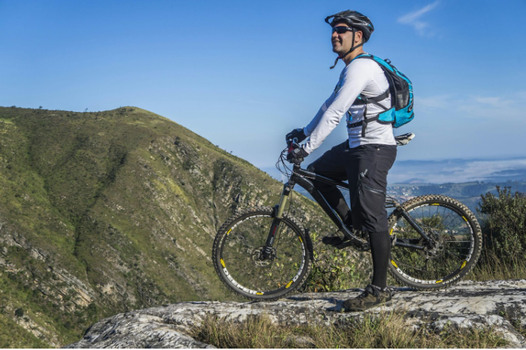 колоездач се радва на гледката към планината