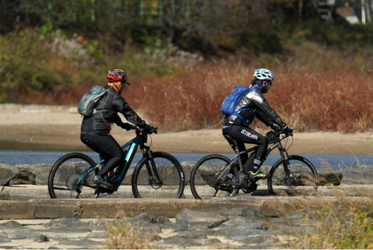 колоездачи с раници карат към планината
